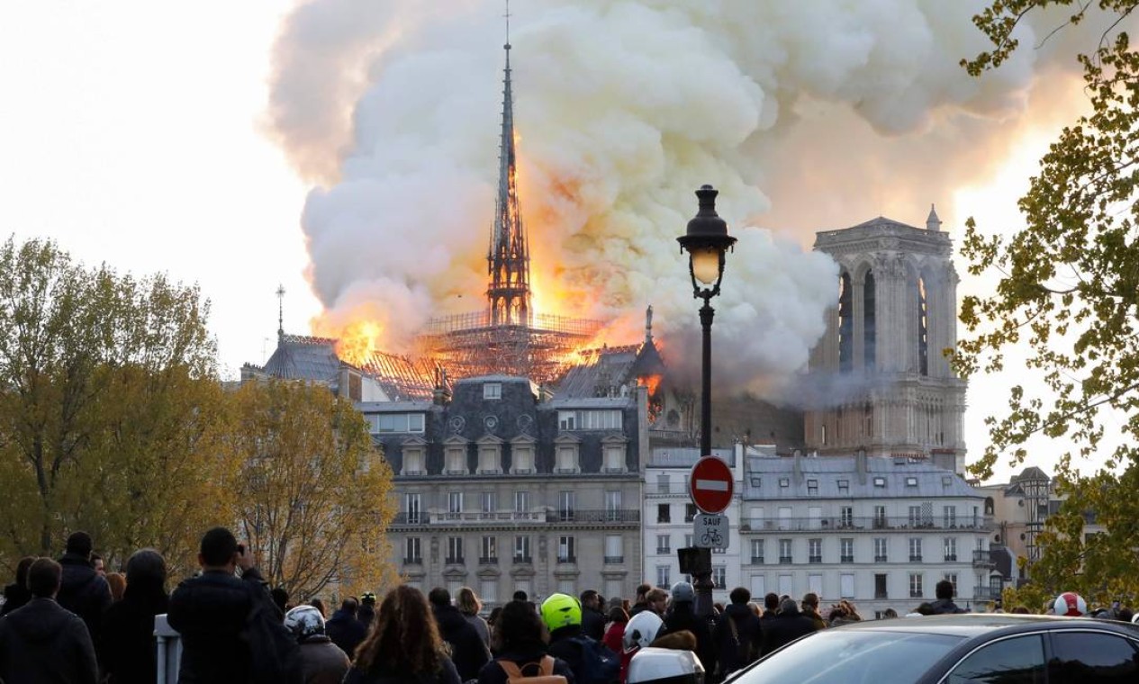 Vista do outro lado do Rio Sena, a Catedral de Notre Dame é tomada pela fumaça e chamas. Catedral tem mais de 850 anos Foto: FRANCOIS GUILLOT / AFP