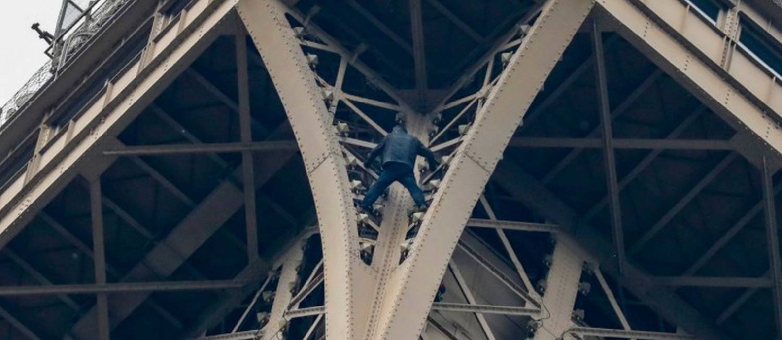 Homem pendurado na Torre Eiffel sem nenhuma proteção nesta segunda-feira Foto: FRANCOIS GUILLOT / AFP