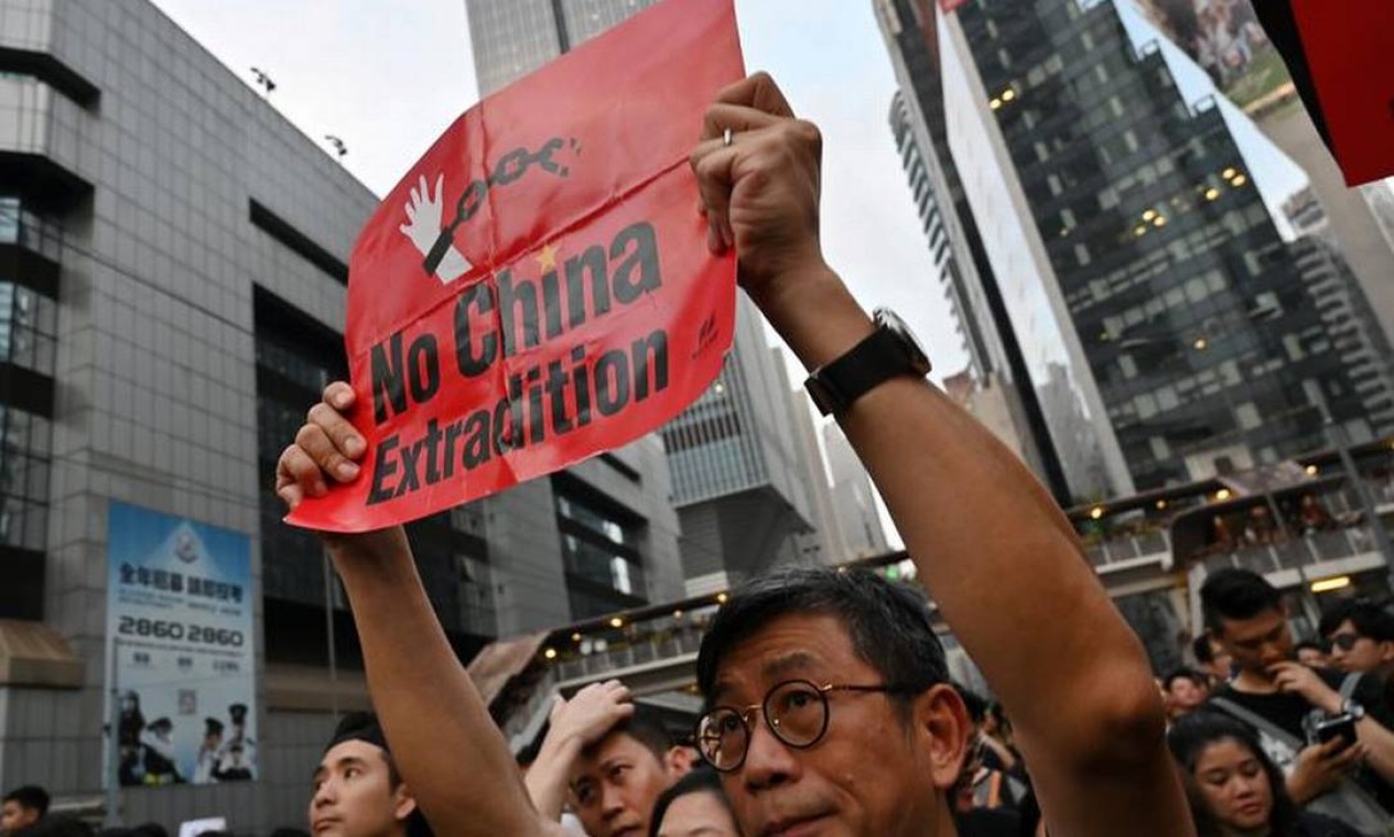 Manifestante segura cartaz contra o projeto de lei: população da ex-colônia britânica teme ficar à mercê do Judiciário da China continental, nebuloso e controlado pelo Partido Comunista Foto: HECTOR RETAMAL/AFP