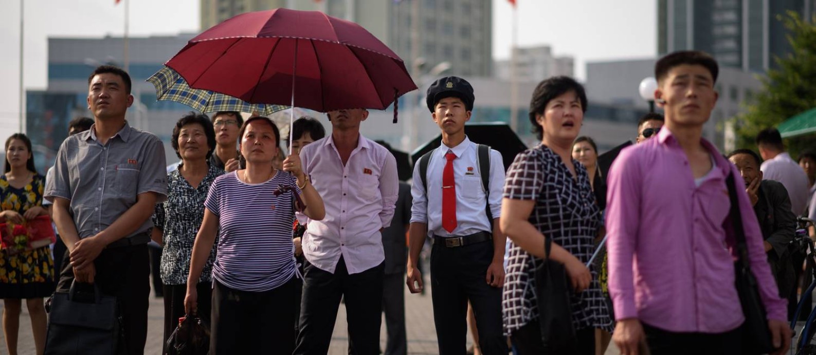Chineses assistem em praça de Pequim à transmissão da visita de Xi à Coreia do Norte; guerra comercial virou assunto do dia a dia Foto: ED JONES / AFP/21-6-2019