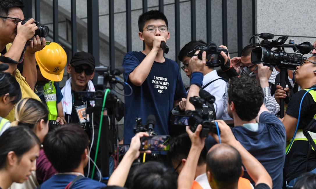 Preso três vezes, o estudante de Ciências Sociais Joshua Wong fala a manifestantes em frente à sede do governo local Foto: ANTHONY WALLACE / AFP
