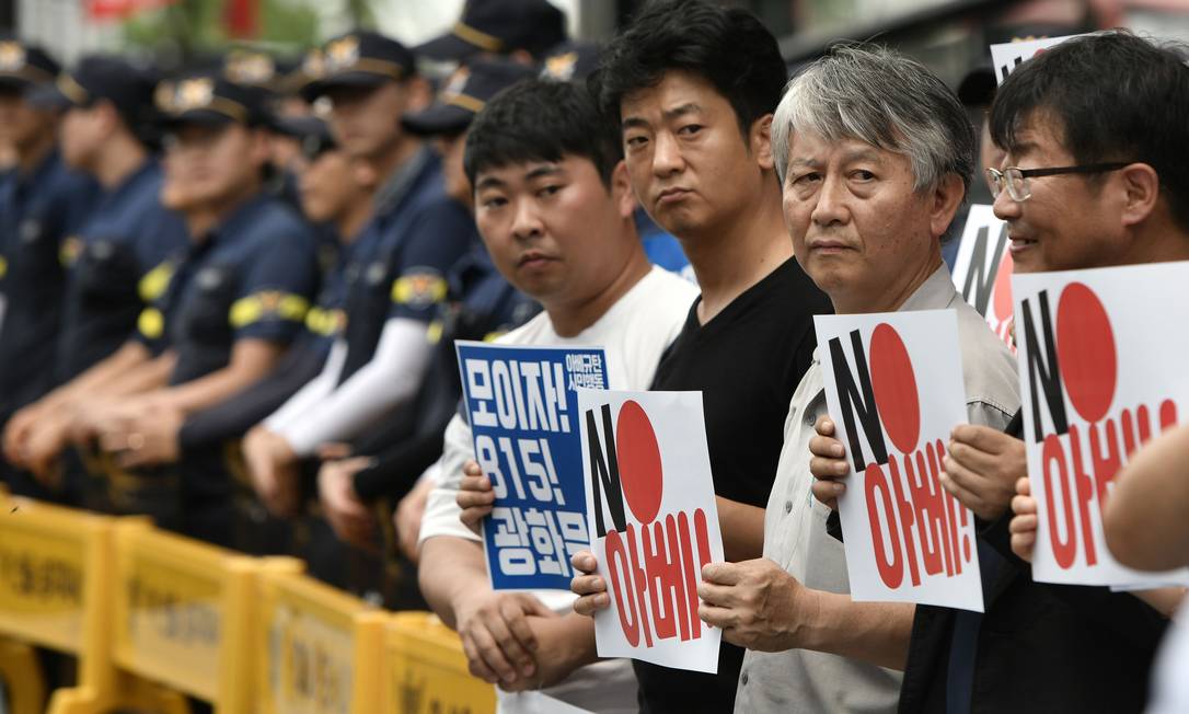Manifestantes sul-coreanos levam cartazes contra o premier japonês, Shinzo Abe, durante protesto em Seul; nesta sexta, governo sul-coreano reagiu a medidas comerciais do Japão Foto: JUNG YEON-JE / AFP