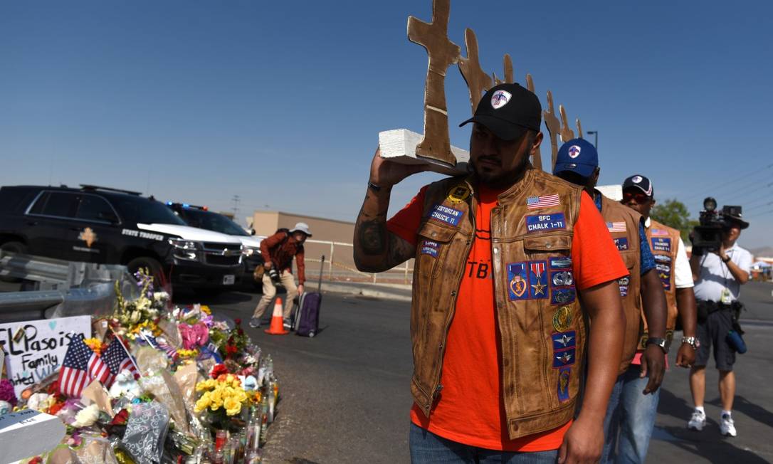 Membros de um grupo de motoqueiros carregam cruzes de papelão para um memorial dois dias depois de um ataque a tiros em El Paso, Texas Foto: CALLAGHAN O'HARE / REUTERS 7-8-19