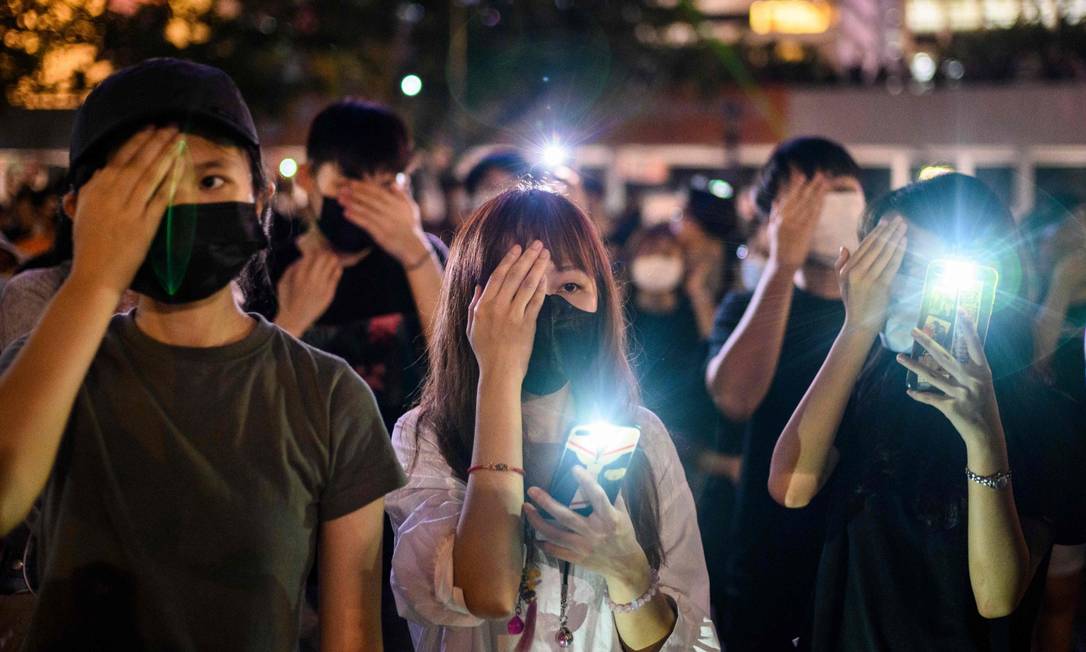 Estudantes tapam os olhos em protesto contra violência policial em repressão em Hong Kong Foto: ANTHONY WALLACE / AFP