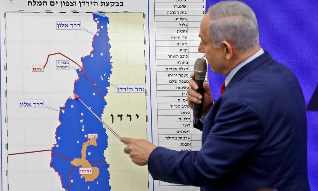 O premier de Israel, Benjamin Netanyahu, aponta para um mapa do Vale do Jordão, indicando regiões que pretende anexar se eleito Foto: MENAHEM KAHANA / AFP 10-9-19
