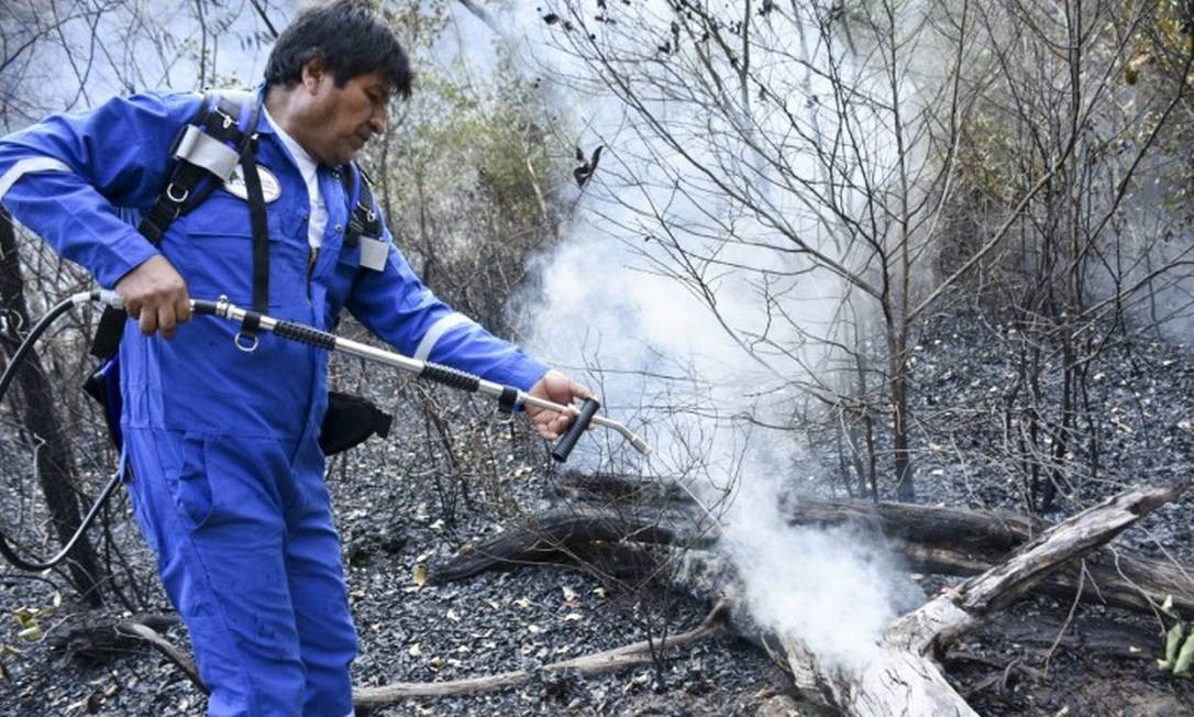 O presidente da BolÃ­via, Evo Morales, despeja Ã¡gua sobre chamas em Santa Rosa, comunidade no Leste da BolÃ­via, na margem da AmazÃ´nia Foto: HO / AFP 28-8-19
