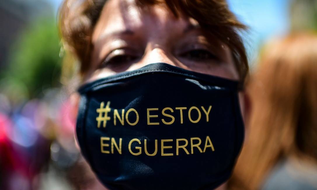 Manifestante usa máscara onde se lê "não estou em guerra"; no começo da crise, Piñera disse que travava "guerra contra um inimigo poderoso" Foto: MARTIN BERNETTI / AFP