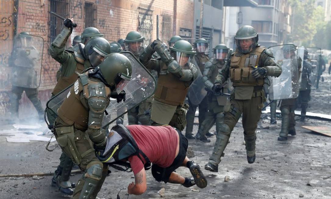 Policiais golpeiam homem durante protesto em Santiago Foto: GORAN TOMASEVIC / REUTERS