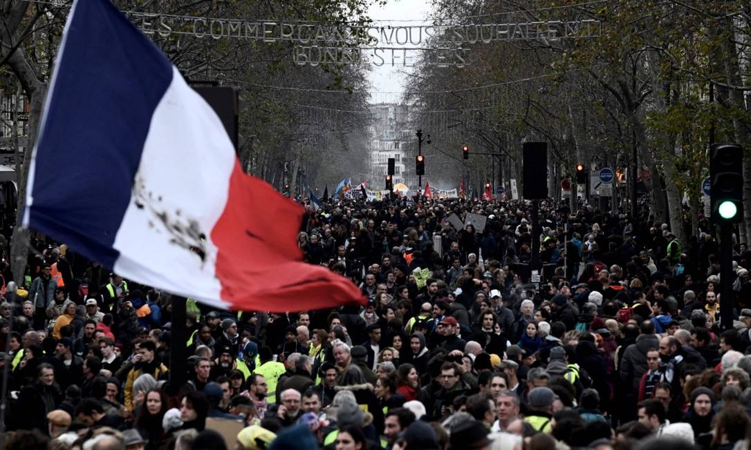 Manifestantes balançam bandeira gigante da França em protesto contra reforma da Previdência planejada pelo governo de Emmanuel Macron Foto: PHILIPPE LOPEZ / AFP
