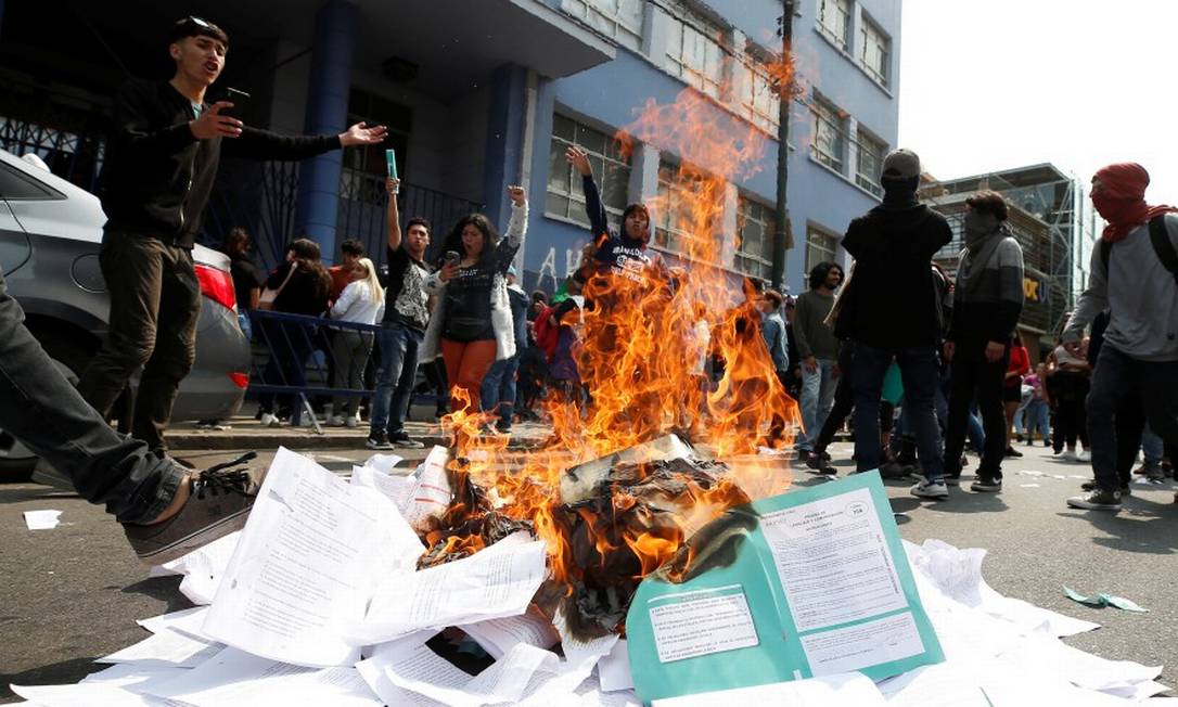 Manifestantes queimam provas em protesto no Chile Foto: RODRIGO GARRIDO / REUTERS
