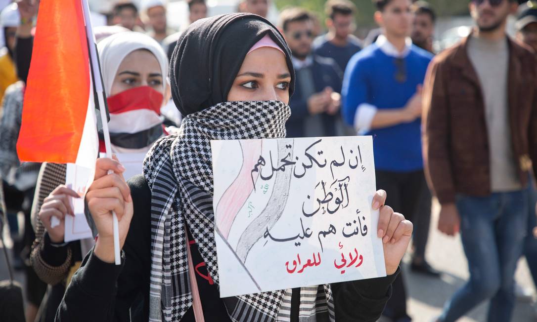 Protesto estudantil na cidade de Basra pede a saída dos EUA e do Irã do Iraque. "Se você não se importa com seu país, então você é um peso para ele. Minha lealdade é com o Iraque", diz o cartaz Foto: HUSSEIN FALEH / AFP