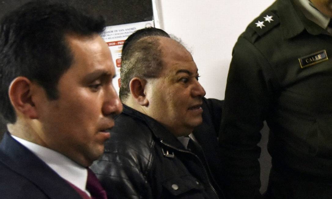 Bolivian former Government Minister Carlos Romero (C) is escorted by police upon his arrival to La Paz prosecutor's office on January 14, 2020, to face anti-corruption prosecutors after being arrested. - Romero was one of around 10 Bolivian officials who took refuge in the Mexican ambassador's residence after Bolivia's former President Evo Morales resigned on November 10 and fled to Mexico following a wave of post-election violence. (Photo by AIZAR RALDES / AFP) Foto: AIZAR RALDES / AFP