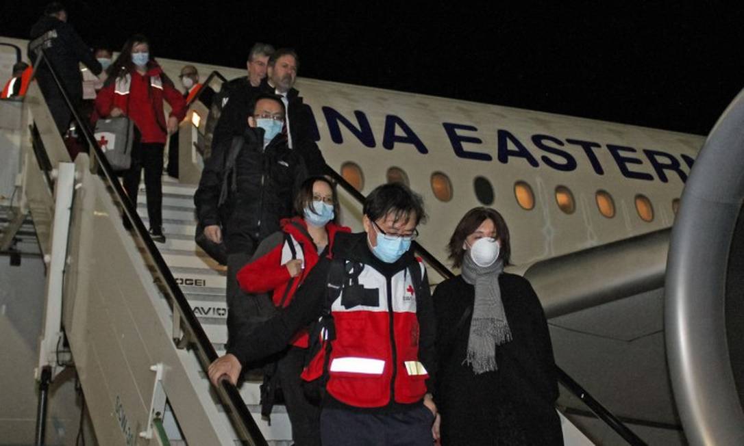 Médicos chineses desembarcam na Itália vindos de Xangai para ajudar a combater a epidemia de Covid-19 no país Foto: STRINGER / AFP