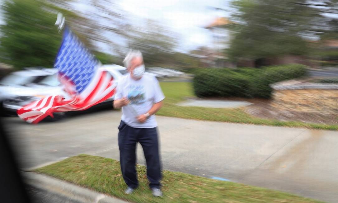 Um homem balançando uma bandeira dos Estados Unidos no estado da Flórida Foto: TOM BRENNER / REUTERS