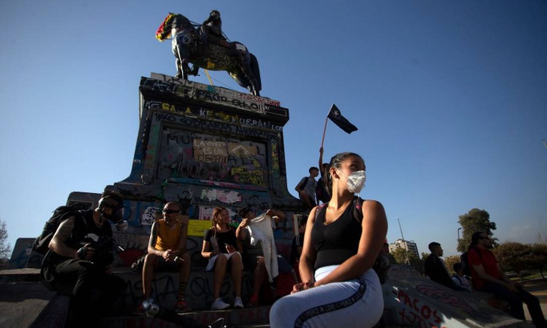 Manifestantes usam máscara contra coronavírus na Praça Itália, rebatizada Praça da Dignidade, em Santiago, no Chie Foto: CLAUDIO REYES / AFP