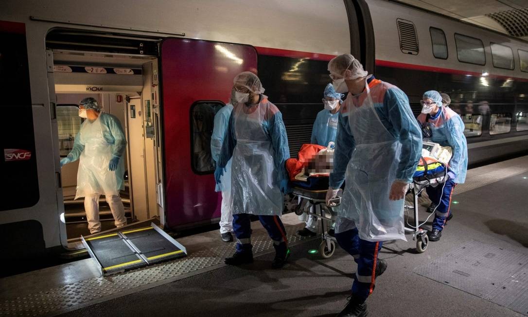 Médicos colocam paciente de Covid-19 a bordo de trem de alta velocidade para transportá-lo para região com vagas em hospitais Foto: POOL / via REUTERS