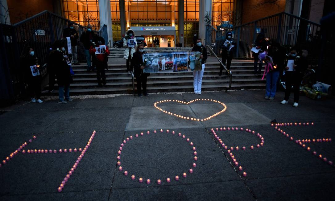 Profissionais de saúde formam a palavra 'esperança' (hope) com velas, durante homenagem a vítimas da Covid-19 Foto: JOHANNES EISELE / AFP