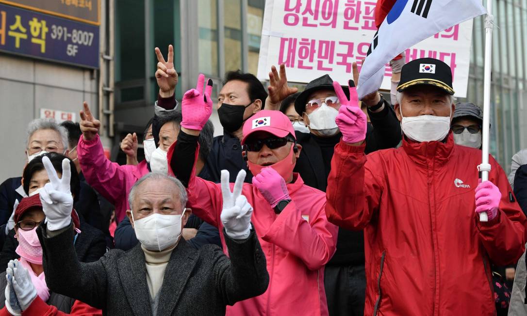 Apoiadores da oposição fazem campanha usando máscara em Seul Foto: JUNG YEON-JE / AFP
