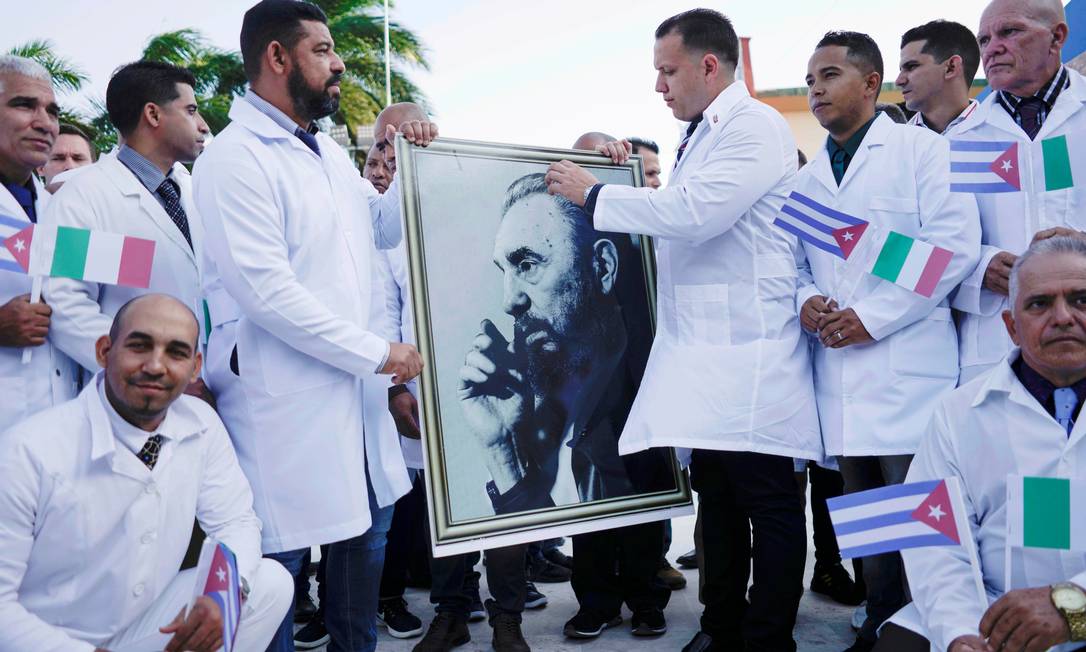 Médicos cubanos com a foto de Fidel Castro, em cerimônia em Havana, antes do embarque para a Itália para ajudar no combate a Covid-19 Foto: Alexandre Meneghini / REUTERS