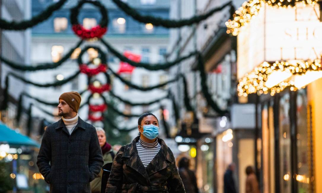 Pessoas caminham por rua decorada para o Natal em Estocolmo Foto: JONATHAN NACKSTRAND / AFP