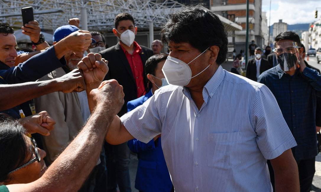O ex-presidente da Bolívia Evo Morales, usando máscara no rosto, cumprimenta apoiadores na chegada para visitar uma seção eleitoral no centro de Caracas, em 6 de dezembro Foto: FEDERICO PARRA / AFP