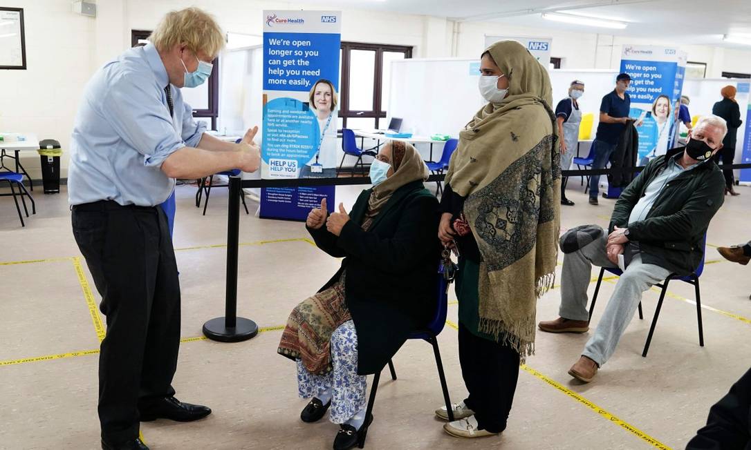 O primeiro-ministro do Reino Unido, Boris Johnson, gesticula para pessoas na fila para receber a vacina em Batley, Norte da Inglaterra, em 1º de fevereiro Foto: JON SUPER / AFP