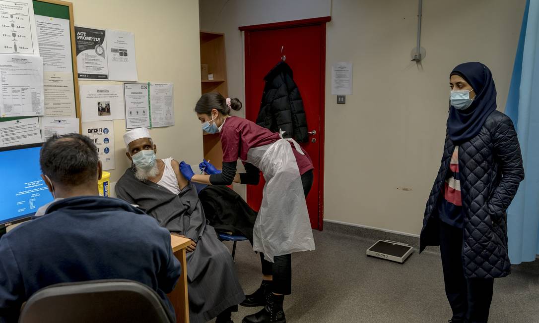 Filha vê seu pai de 79 anos ser vacinado contra o coronavírus em Londres Foto: ANDREW TESTA / NYT