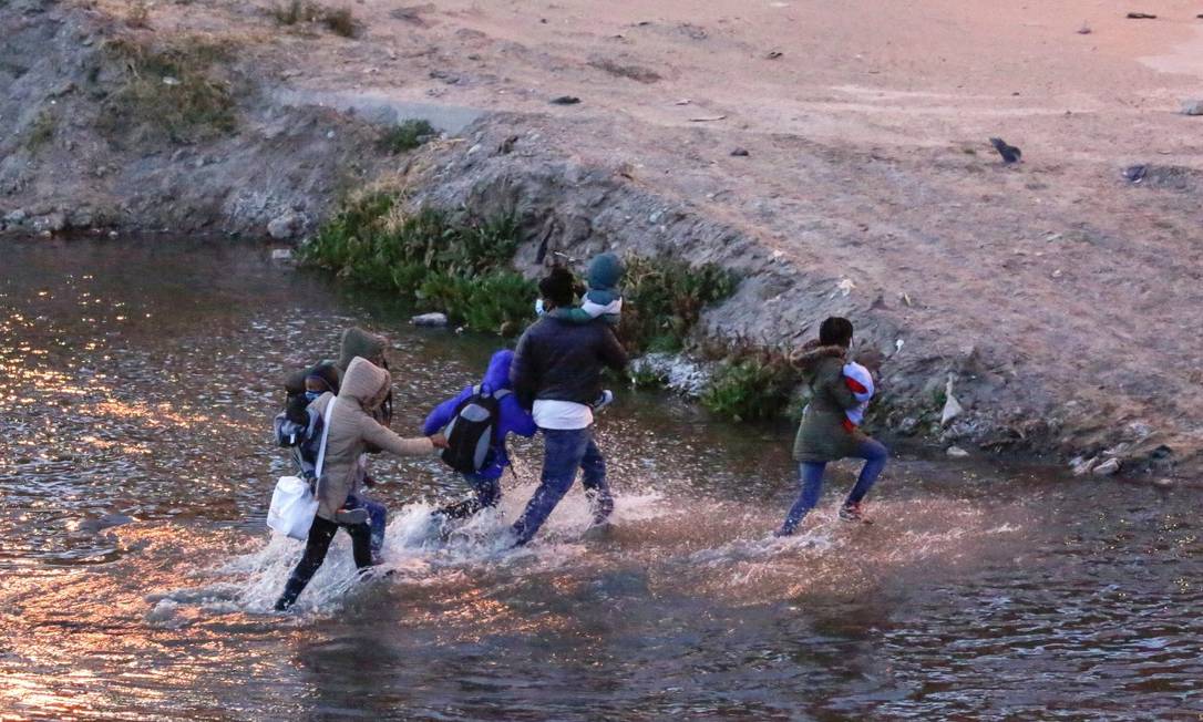 Migrantes cruzam o rio Rio Bravo para se entregar a agentes da Patrulha de Fronteira dos EUA e solicitar asilo em El Paso, Texas Foto: JOSE LUIS GONZALEZ / REUTERS