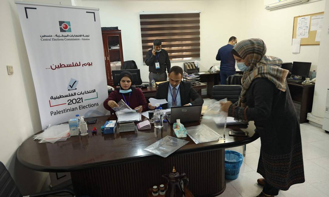 Empregados da Comissão Eleitoral Central Palestina preparam documentos no escritório em Gaza Foto: MOHAMMED ABED / AFP