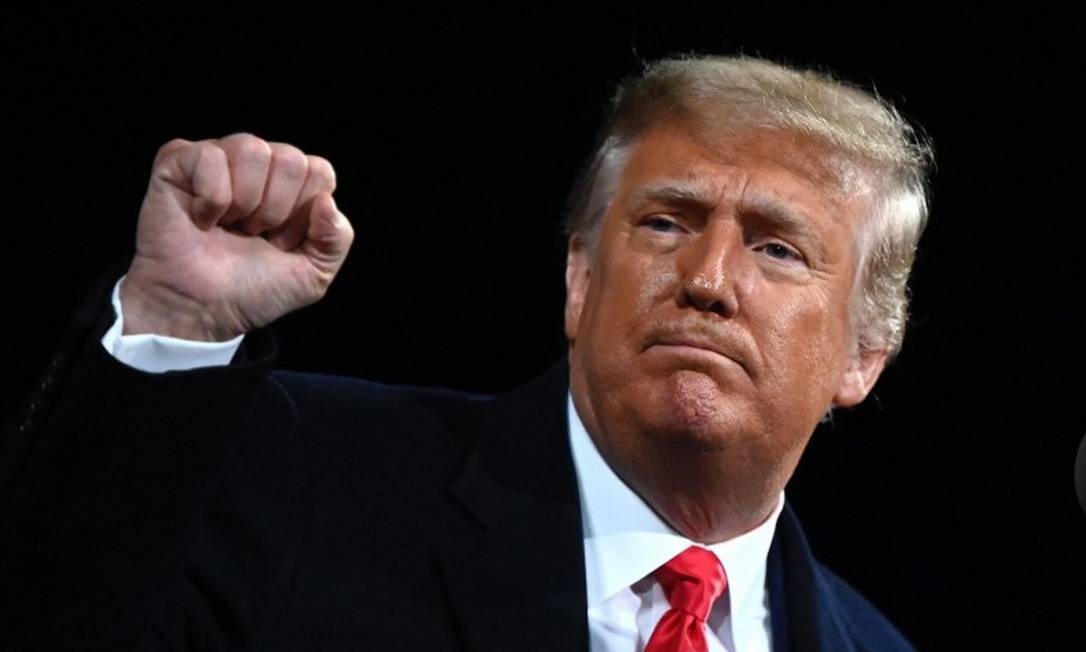 Então presidente americano Donald Trump ergue o punho cerrado, em foto de dezembro de 2020 Foto: ANDREW CABALLERO-REYNOLDS / AFP