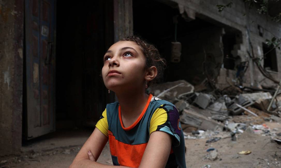 Menina em frente a ruínas de sua casa, destruídas por bombardeio de Israel em Gaza Foto: MOHAMMED ABED / AFP