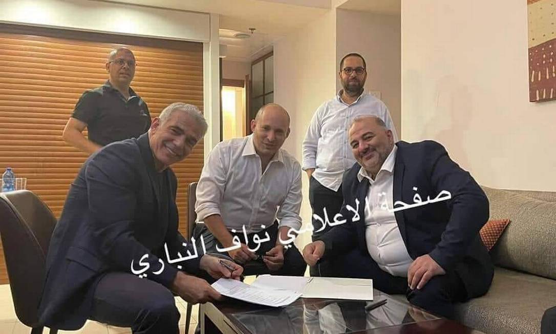 O centrista Yair Lapid, o ultradireitista Naftali Bennett e o líder da Lista Árabe Unida, Mansour Abbas, assinam o acordo para a formação da coalizão Foto: Reprodução