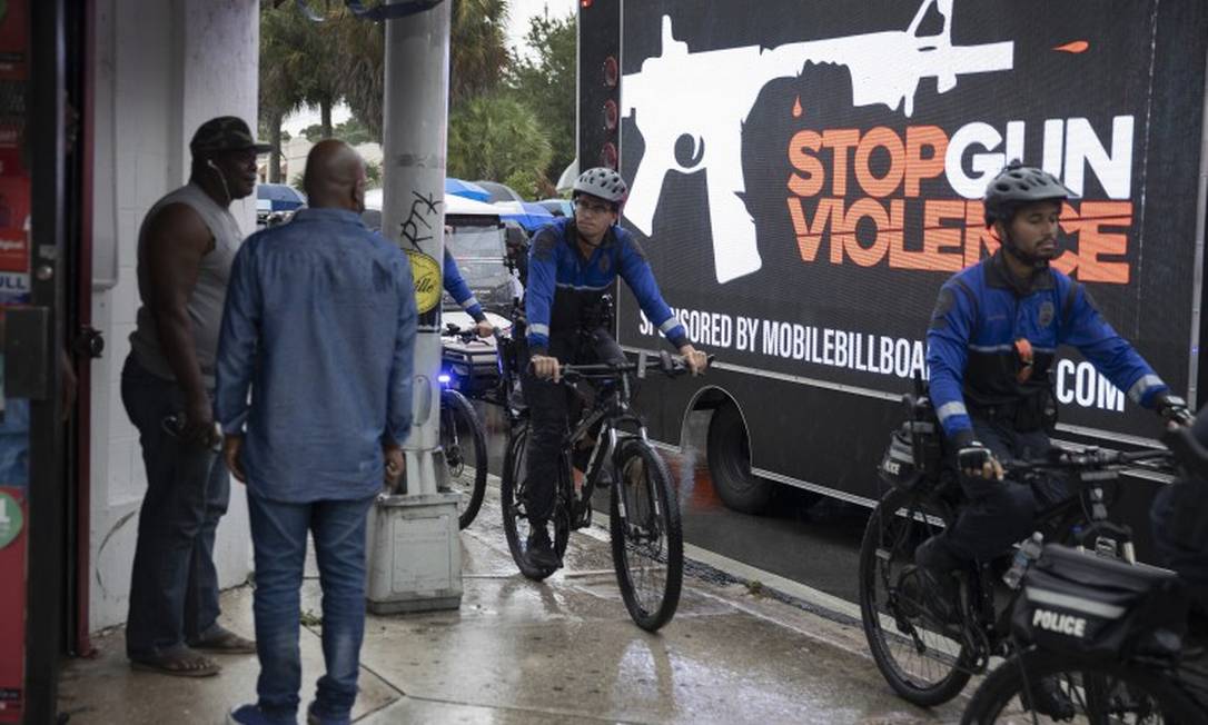 Policiais fazem patrulha de bicicleta enquanto pessoas organizam marcha pela paz e contra a violência armada em Miami Foto: JOE RAEDLE / AFP