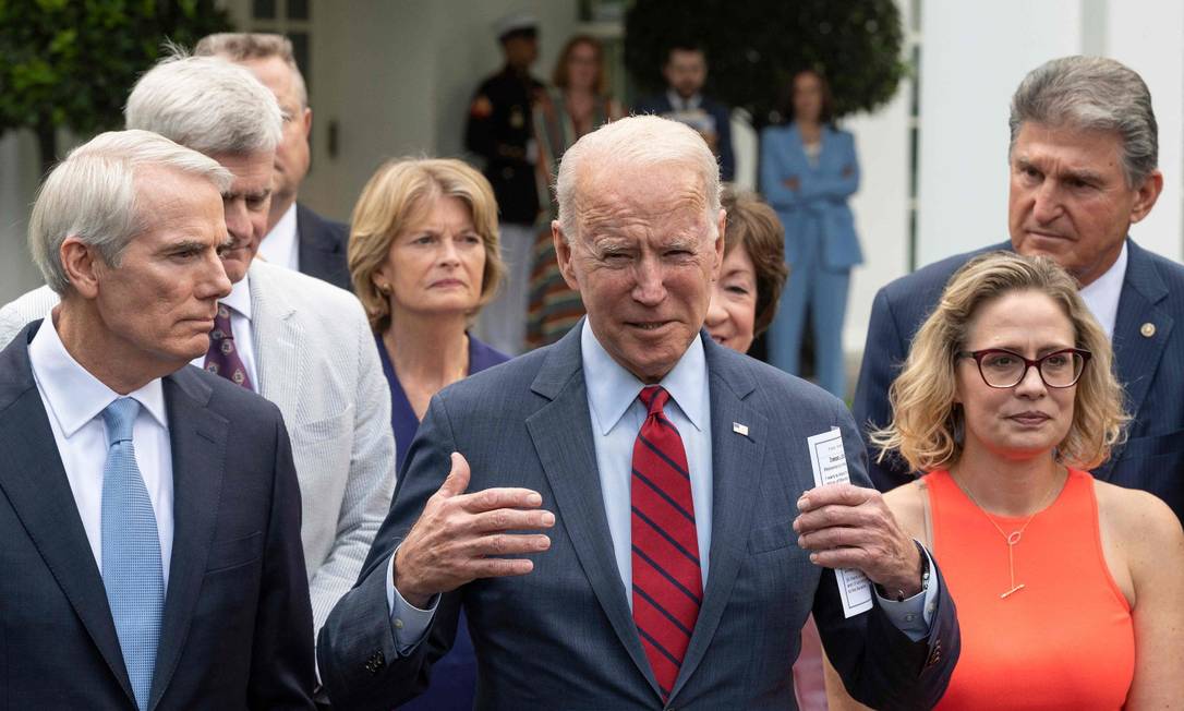 O presidente dos Estados Unidos, Joe Biden, anuncia o acordo cercado por um grupo de senadores dos dois partidos Foto: JIM WATSON / AFP