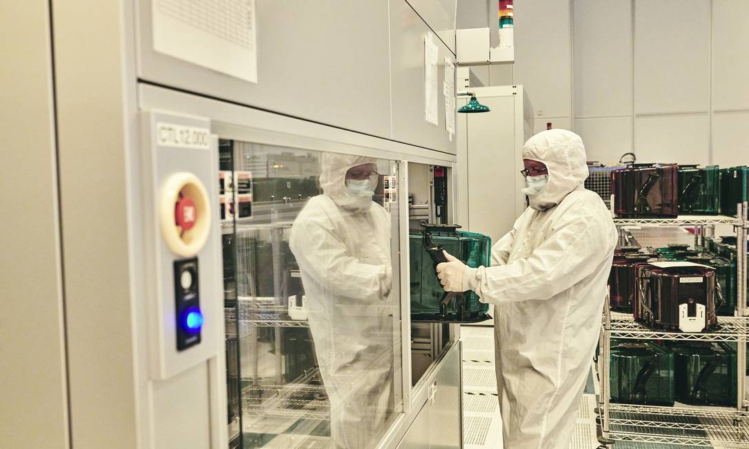 Um funcionário manipula um rack de wafers de silício de uma máquina de fabricação de chips nas instalações de pesquisa da IBM em Albany, Nova York Foto: BRYAN DERBALLA / NYT