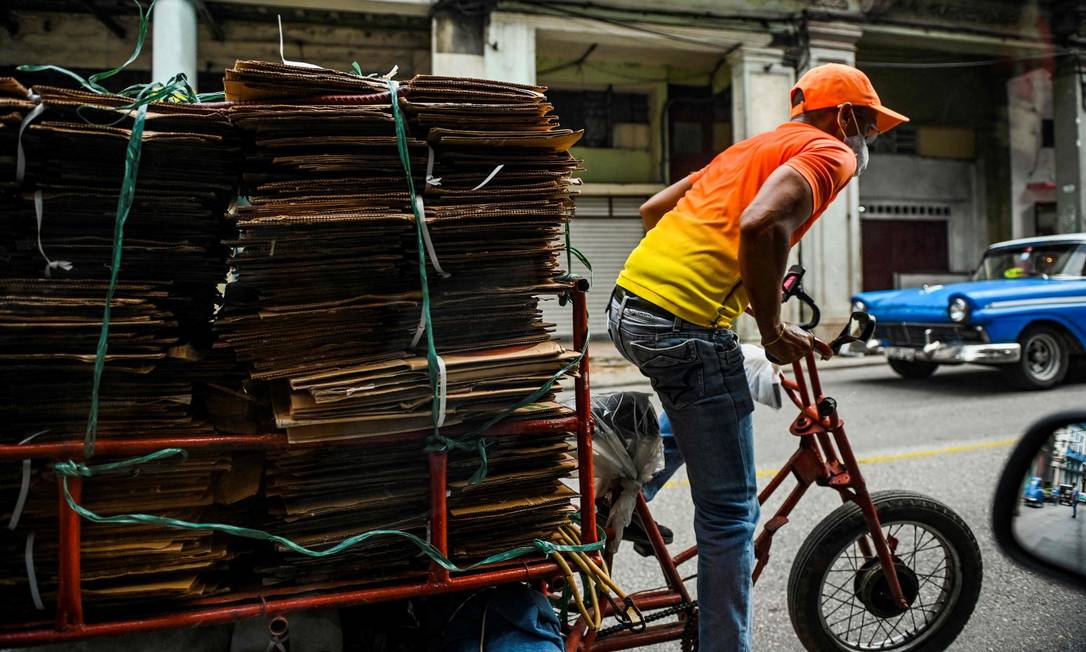 Cubano transporta papelão em bicicleta em Havana, capital de Cuba Foto: YAMIL LAGE / AFP