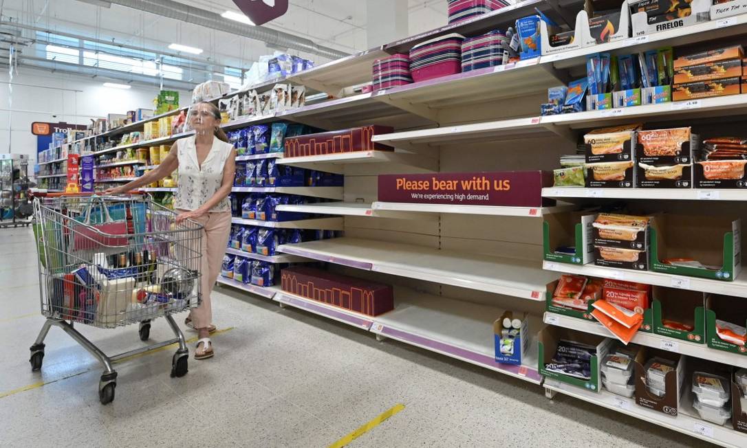 Consumidora em frente a aviso que produtos estão temporariamente indisponíveis em mercado em Nine Elms, no Sul de Londres Foto: JUSTIN TALLIS / AFP