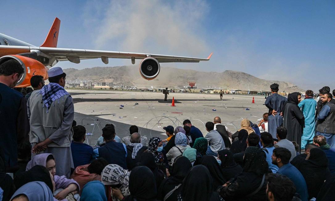 Afegãos no aeroporto de Cabul à espera de um avião na segunda-feira Foto: WAKIL KOHSAR / AFP