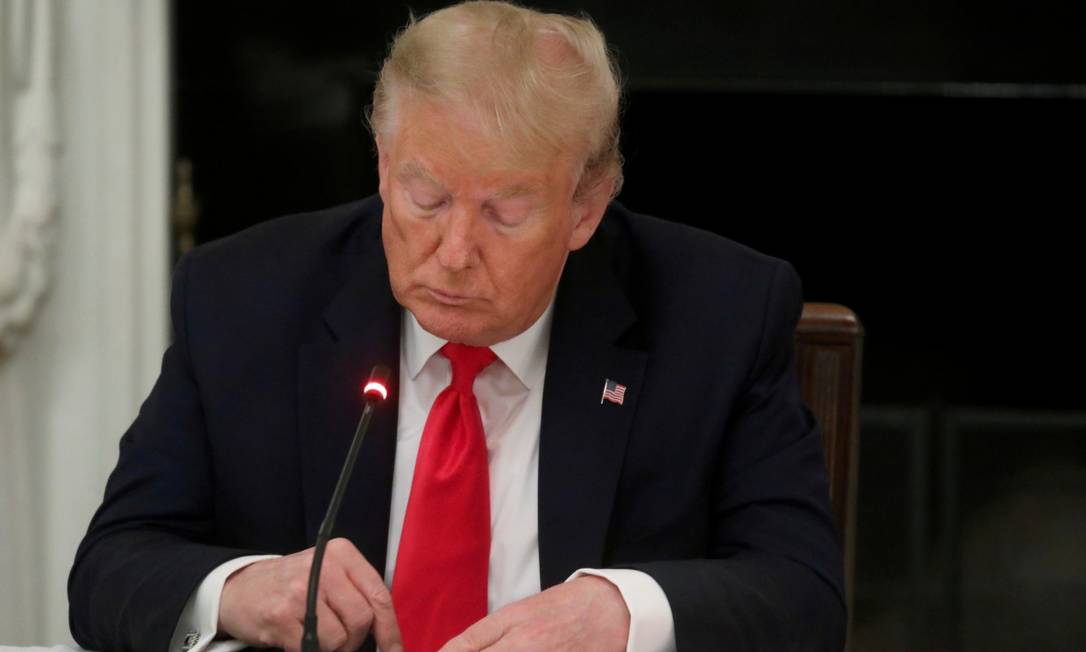 O ex-presidente americano Donald Trump mexe na tela de seu celular em um jantar na Casa Branca no dia 18 de junho de 2020 Foto: Leah Millis / REUTERS