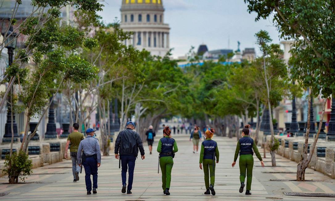 Policiais caminham pelo El Paseo del Prado em Havana nesta segunda-feira Foto: YAMIL LAGE / AFP