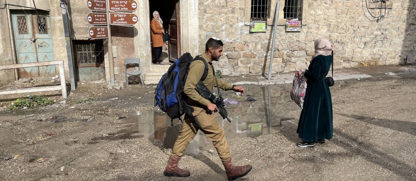 Soldado israelense passa por palestinas em Hebron, que teve seu centro esvaziado e onde foi estabelecida uma segregação entre árabes e judeus Foto: Paola de Orte