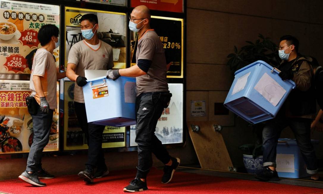 Forças de segurança carregam caixas de material apreendidas na redação do Stand News em Hong Kong Foto: TYRONE SIU / REUTERS