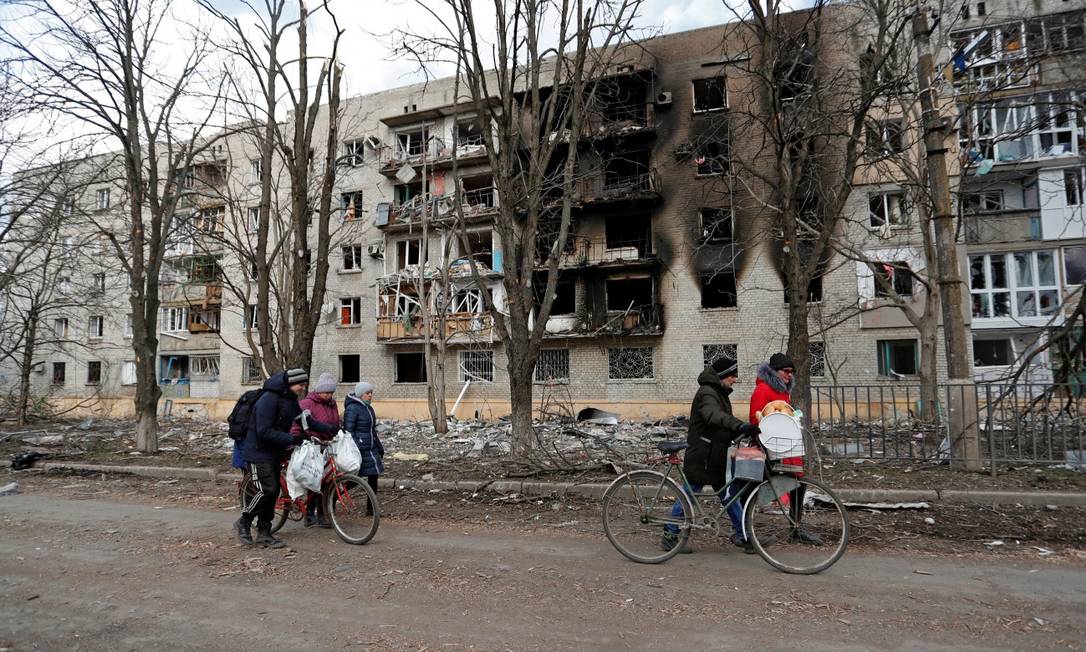 Moradores andam em frente a um prédio danificado na cidade controlada por separatistas de Volnovakha, na região de Donetsk Foto: ALEXANDER ERMOCHENKO / REUTERS