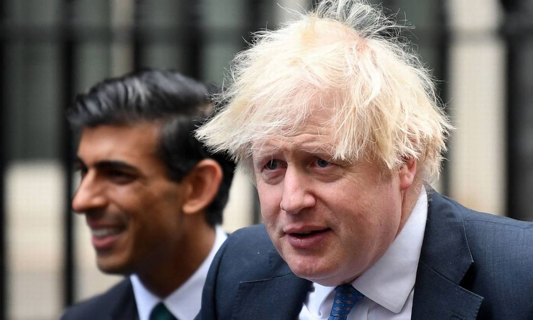 O premier britânico, Boris Johnson, com o chanceler do Tesouro, Rishi Sunak, ao fundo Foto: DANIEL LEAL / AFP