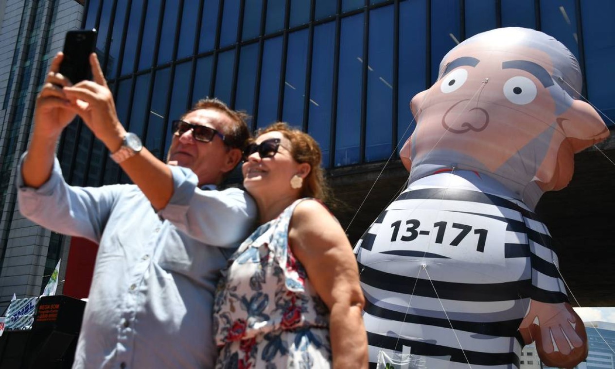 Durante protesto em São Paulo, casal tira selfie com o boneco conhecido como "Pixuleco", que representa o ex-presidente Luiz Inácio Lula da Silva Foto: NELSON ALMEIDA / AFP