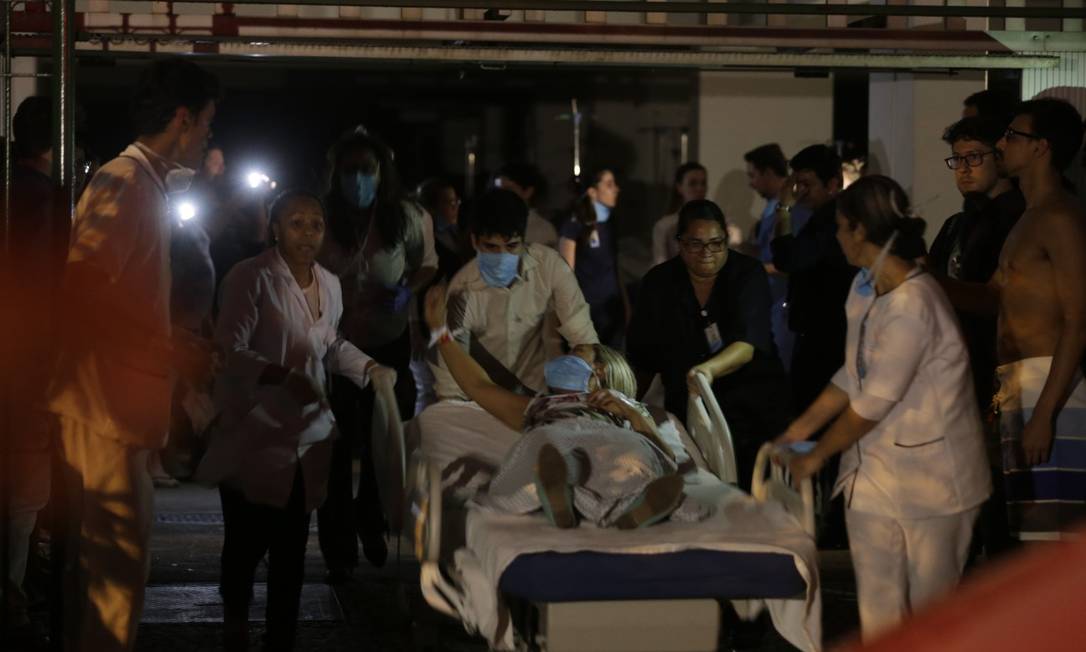 Pacientes foram retirados em macas do hospital por profissionais de saúde Foto: Alexandre Cassiano / Agência Globo