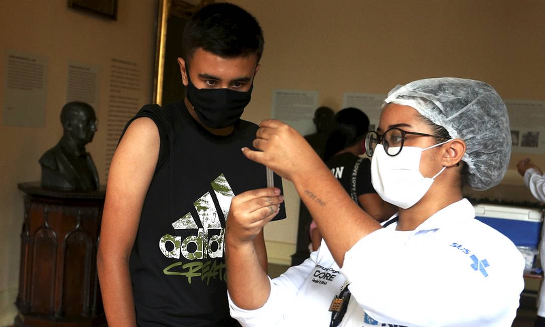 Adolescente observa profissional de saúde preparar a vacina no posto do Palácio do Catete Foto: Fabiano Rocha / Agência O Globo