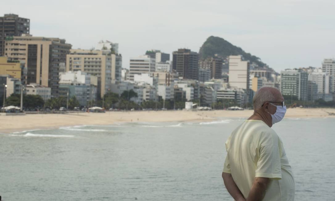 Idoso usando mascara observa a praia do Leblon desde o Mirante Foto: Antonio Scorza / Agência O Globo