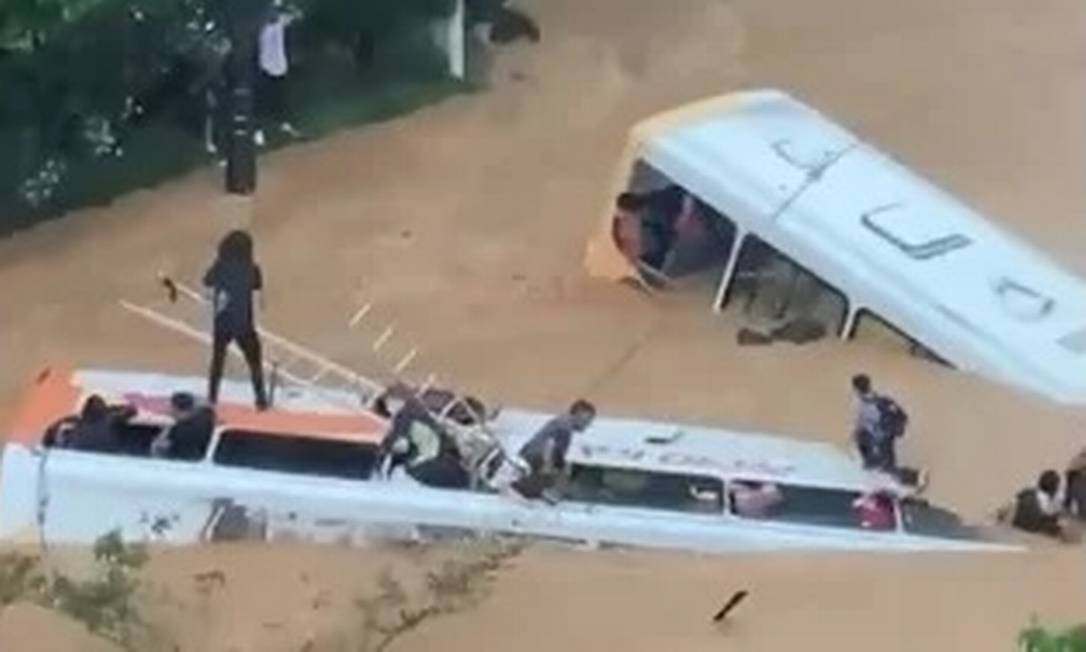 O desespero de passageiros tentando sair de ônibus engolidos pelas águas do temporal em Petrópolis Foto: Reprodução
